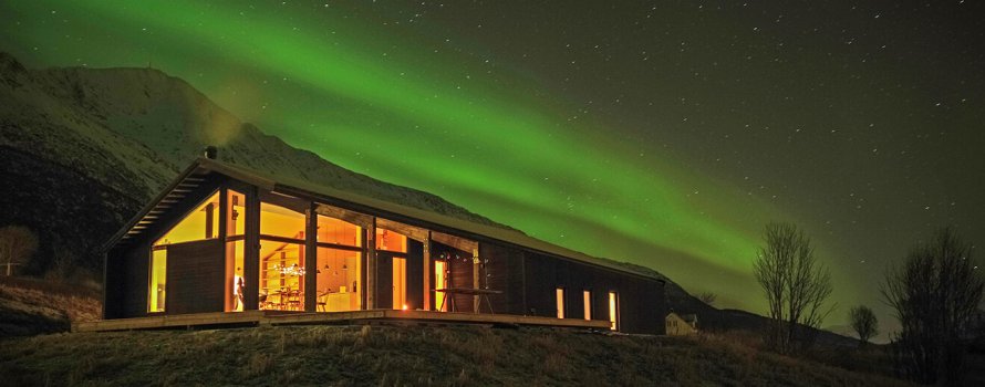 Fjellhytte med nordlys om kvelden