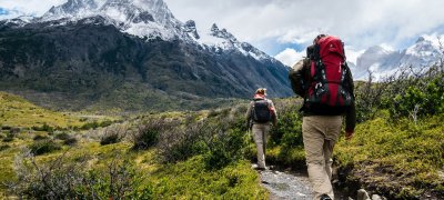 To personer går tur i fjellet med sekk