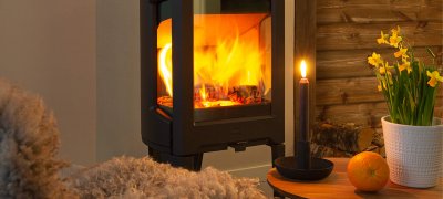 Jøtul F 163 sort vedovn med påskeliljer på en hytte