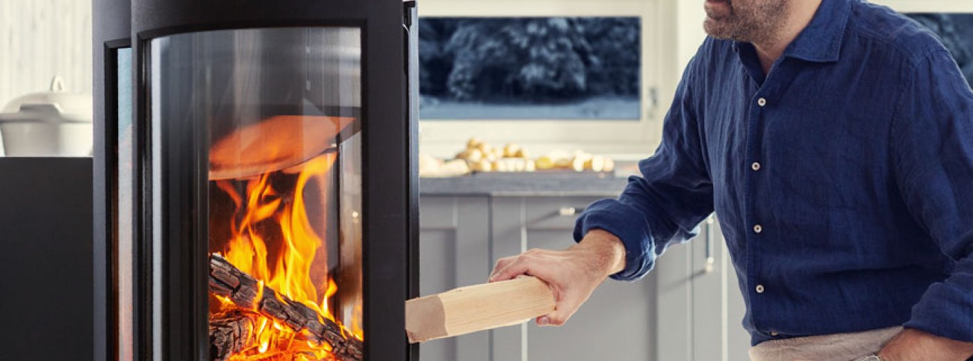Mann fyrer i peisen