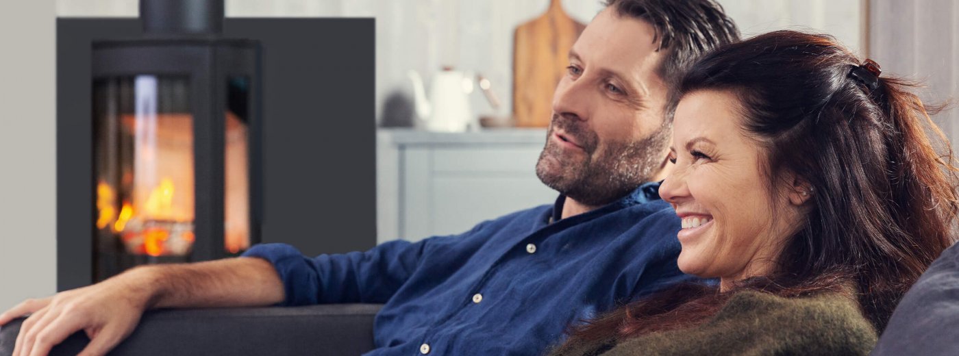 Par som sitter foran vedovnen Jøtul F 373 Advance