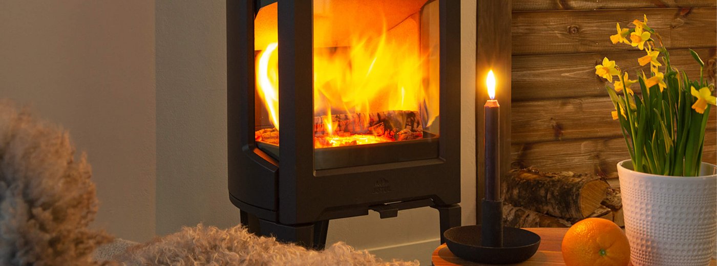 Jøtul F 163 sort vedovn med påskeliljer på en hytte
