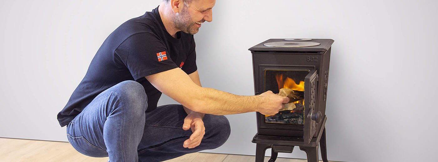 Mann legger ved i vedovnen Jøtul F 602