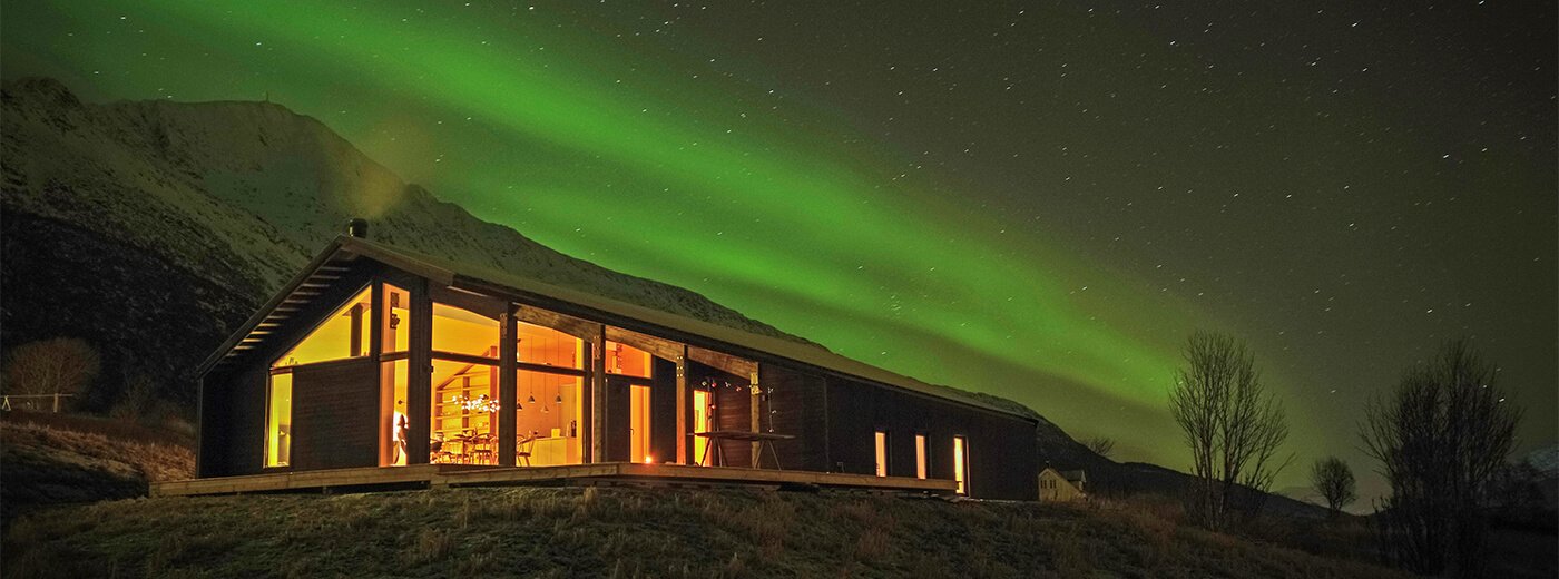 Fjellhytte med nordlys om kvelden